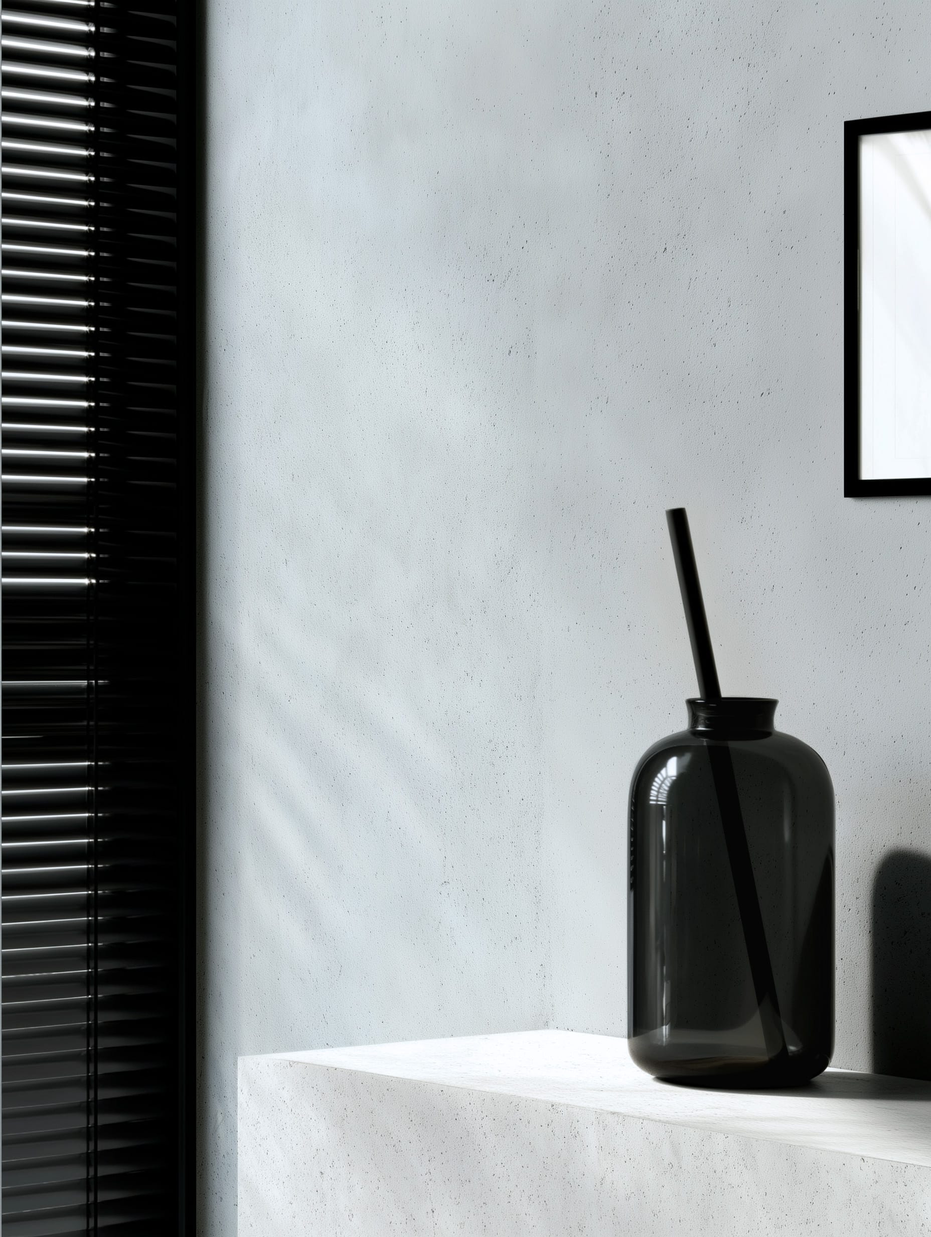 atelier-xvi-urban-graphic-edito-fenetre-graphique-vase-verre-fume-cadre-noir-4x5 Mur gris froid traversé par des bandes de lumière de stores ; grand vase en verre fumé sur socle en béton clair ; cadre noir fin entrant par la droite — ambiance Urban Graphic