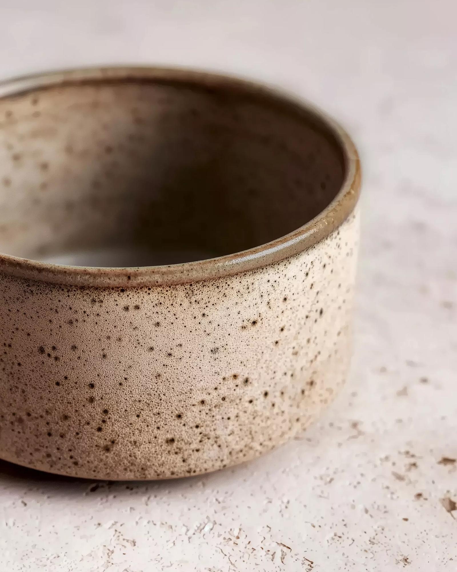 Gros plan sur la texture granuleuse d'une céramique chamottée brute. Illustration de l'esthétique Raw Luxury et des matières naturelles de la collection Organic Atelier XVI.