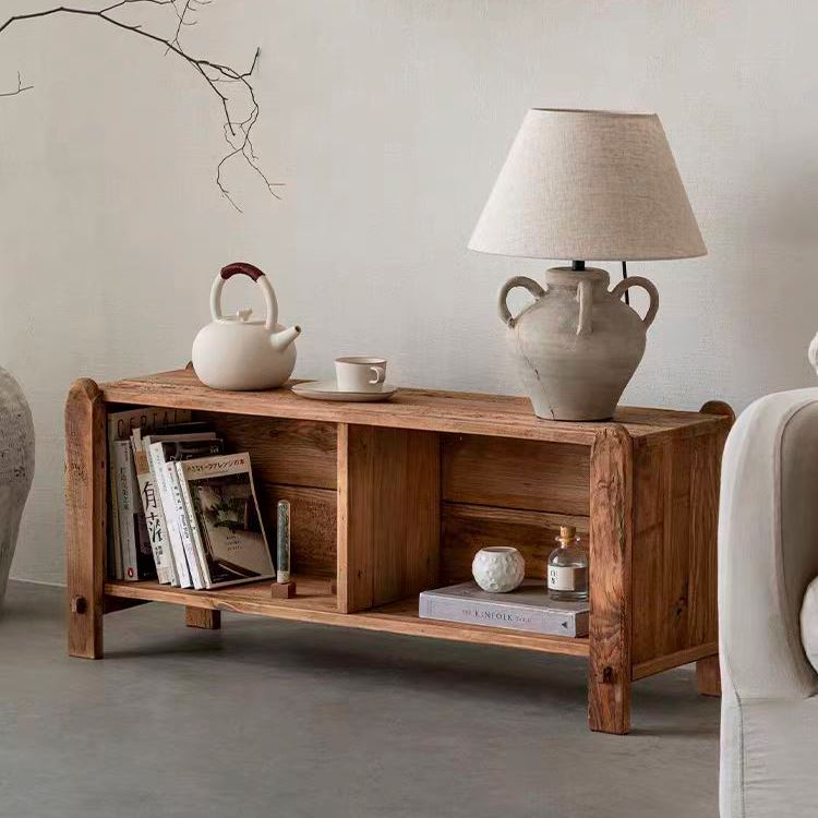 Buffet Nabila en pin massif recyclé finition naturelle, photographié en vue 3/4 avant-gauche dans un salon avec livres et lampe en céramique posés sur le plateau.