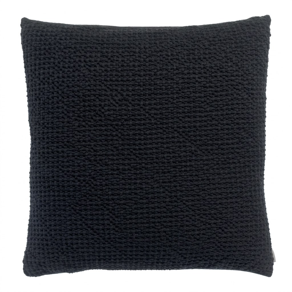 Coussin gaufré noir en coton recyclé, vue de face, relief alvéolé en nid d'abeille et finition stonewash sur fond neutre.