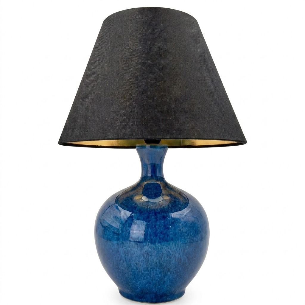 Lampe en céramique bleu marine à glaçure brillante, abat-jour noir à l'intérieur doré, présentée sur fond neutre