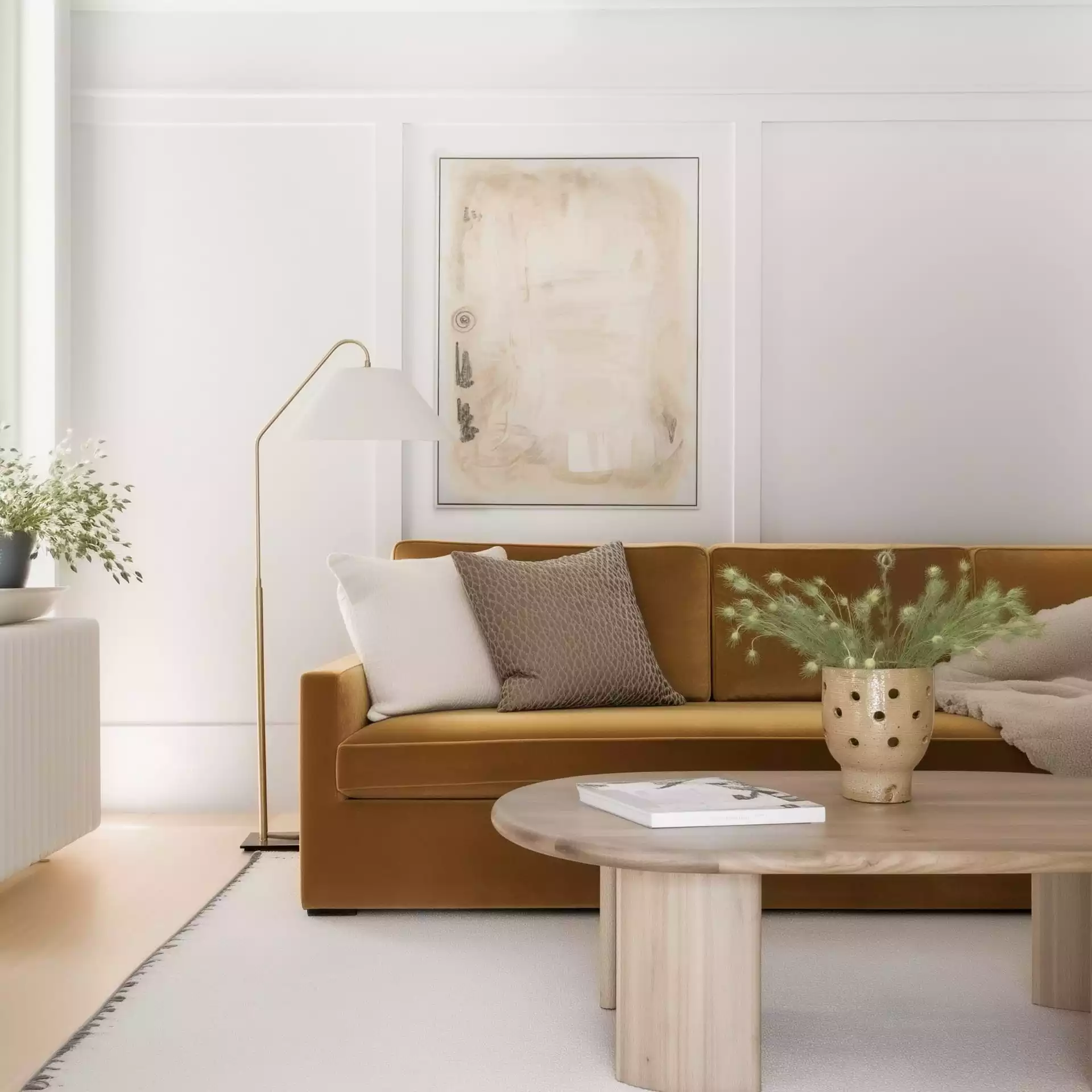 Canapé velours ocre avec coussins crème, lampadaire en laiton brossé, table basse en chêne clair, tableau abstrait beige et vase en céramique — ambiance scandinave chaleureuse