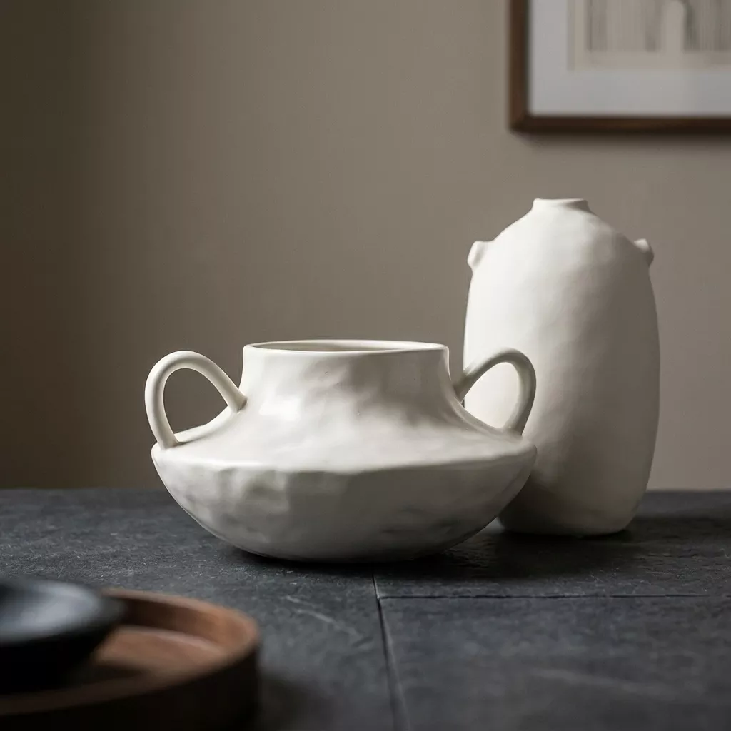 Duo Orelia — vase ovoidé et amphore en grès écru dans une entrée Dark Japandi, ambiance matère et golden hour