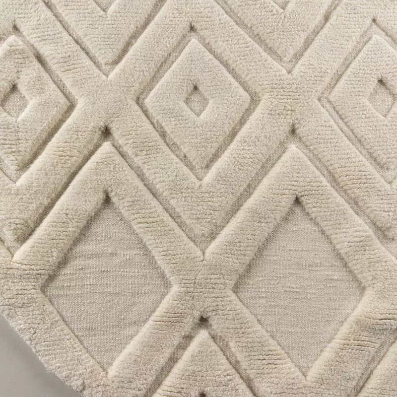Tapis rond Lina en laine écru au pied d'un lit, chambre Japandi à lambris chêne chaud, plaid charcoal et shearling
