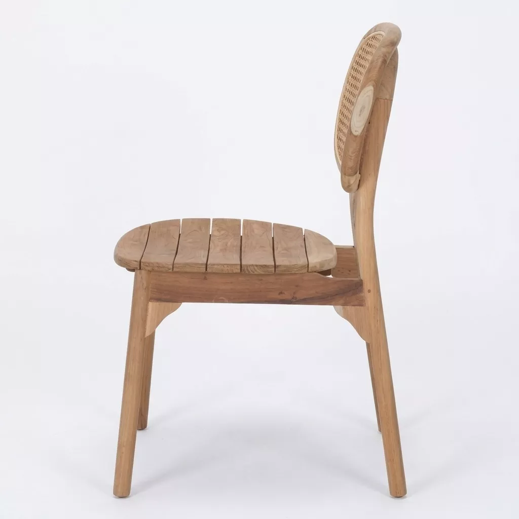 Chaise en teck massif naturel vue de profil, assise à lattes teck, dossier ovale cannage rotin, fond neutre gris clair