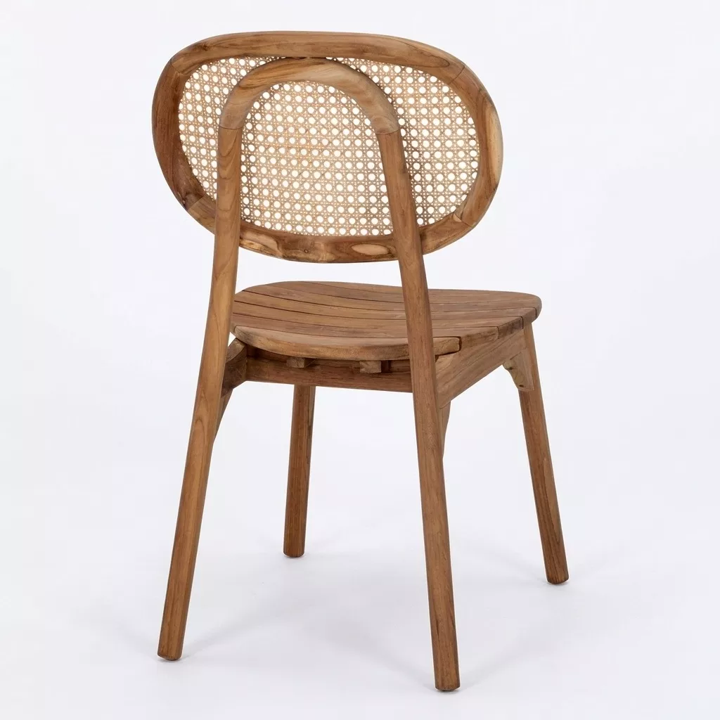 Chaise teck massif vue de trois-quarts arrière, dossier ovale cannage rotin visible, assise à lattes, fond neutre