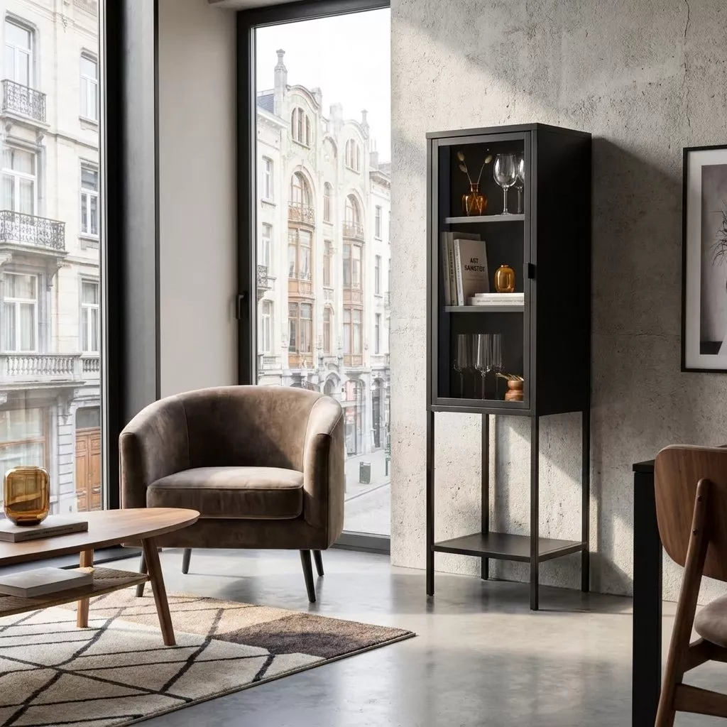 Vitrine colonne noire en acier thermolaqué et verre clair, posée près d'une grande baie vitrée dans un salon contemporain.
