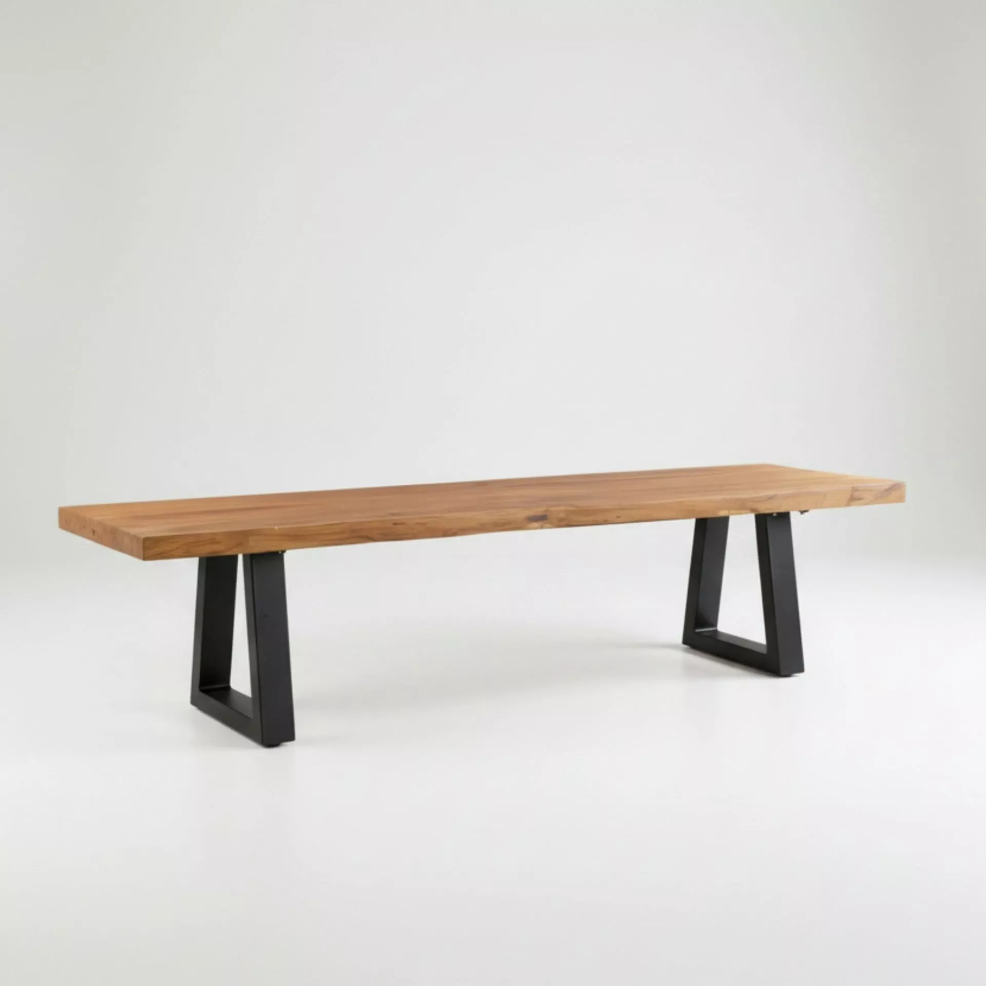 Banc en teck recyclé massif sur pieds fer trapézoïdaux noir mat, vue trois-quarts, grain brun doré-miel veiné, fond gris clair