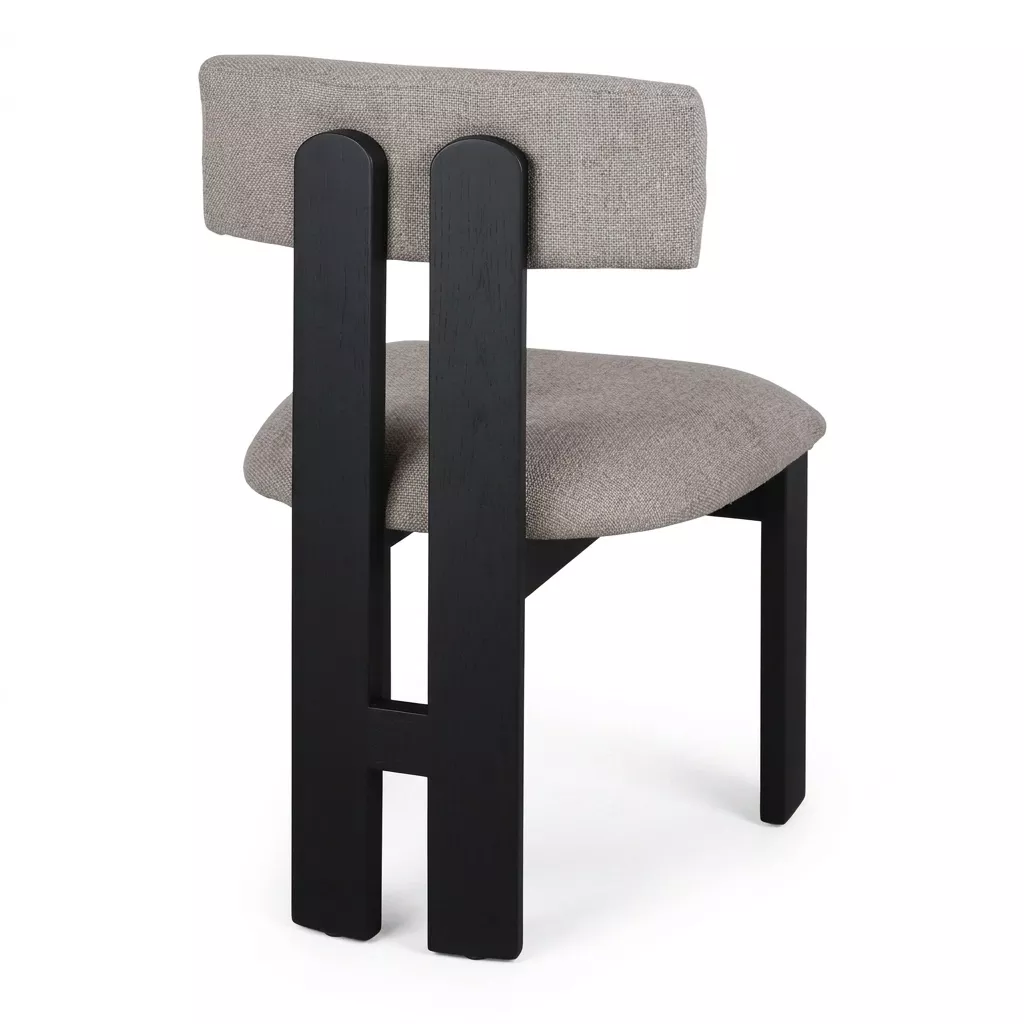 Chaise tissu taupe vue de dos, piétement orme laqué noir mat aux montants ajourés et assise rembourrée, fond neutre clair