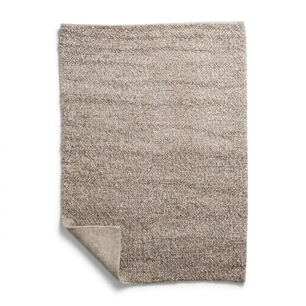 Tapis bouclette beige grège laine et viscose, packshot fond blanc, coin relevé révélant la trame dos en coton naturel