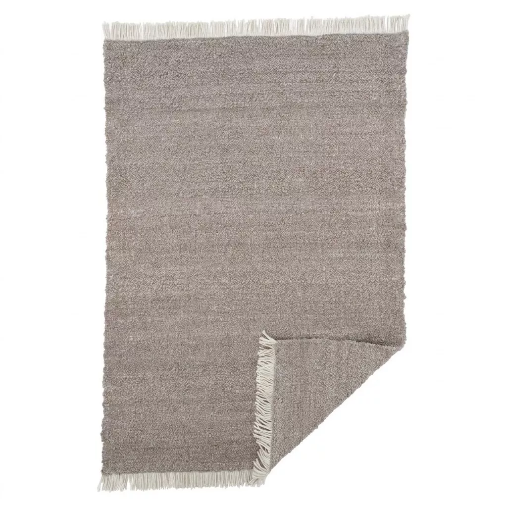 Tapis laine tissée main greige, vue de dessus sur fond blanc, coin retourné révélant la trame, franges écrues sur les côtés courts