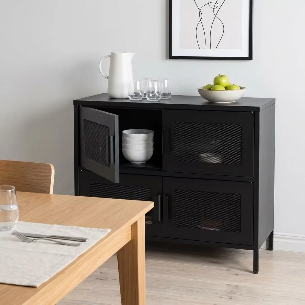 Buffet bas en acier noir mat à portes en grillage losange dans une salle à manger, affiche au trait et table en bois clair