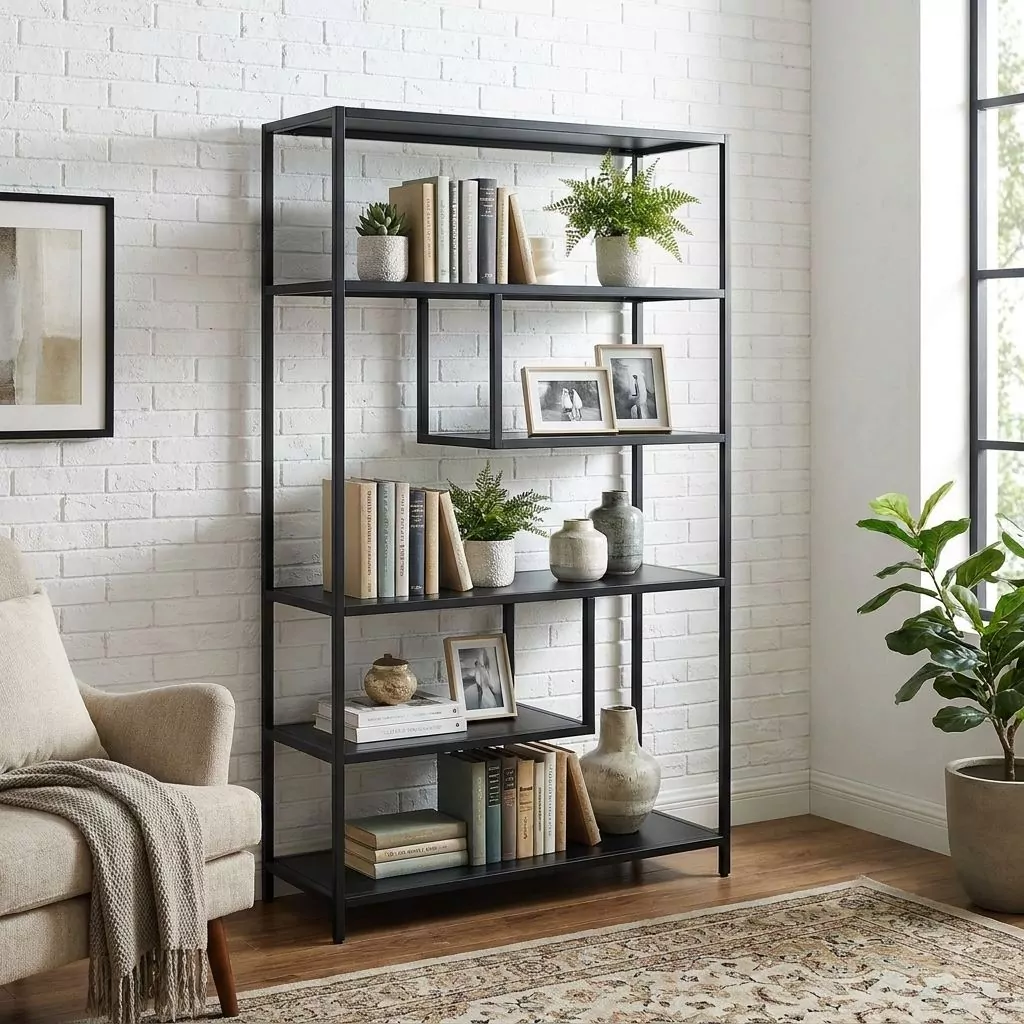 Étagère métal noir mat dans un salon à mur briques peintes, garnie de livres et vases, près d'un fauteuil bouclé écru.