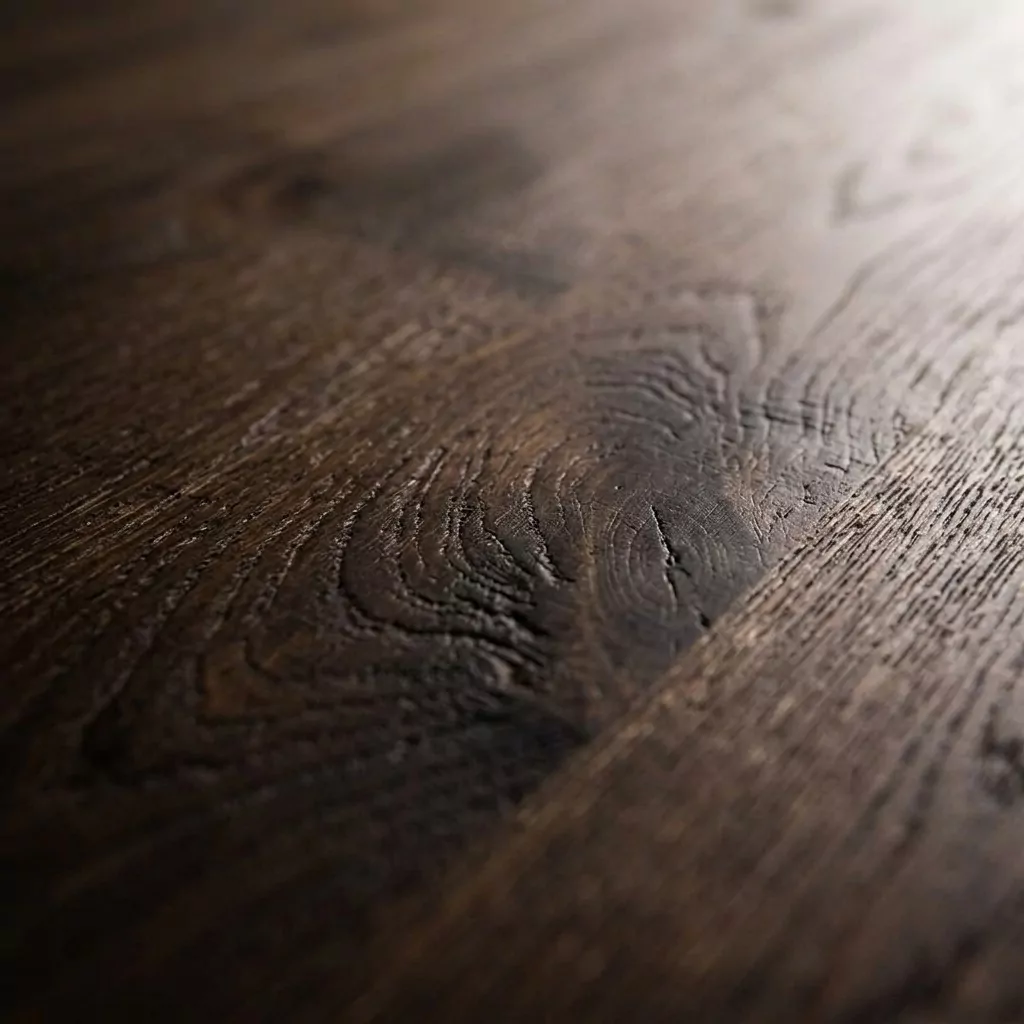 Détail du plateau en teck massif, grain longitudinal et veinage contrasté révélés par une lumière rasante