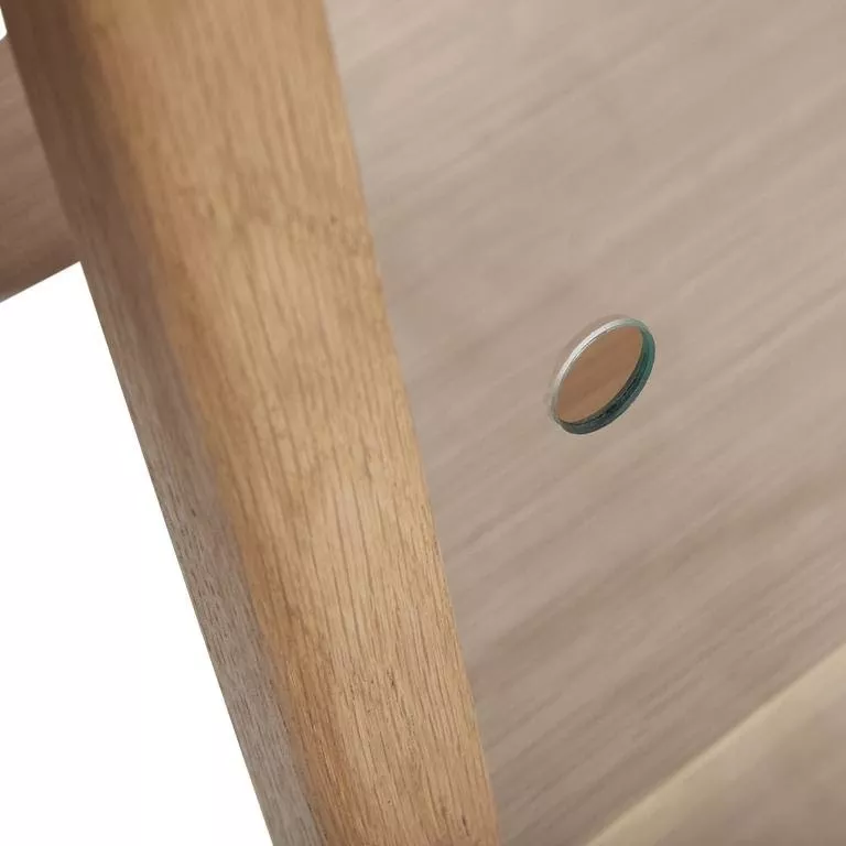 Détail de l'oculus circulaire creusé dans la porte vitrée, grain de chêne clair miel en fond, finition mate lisse