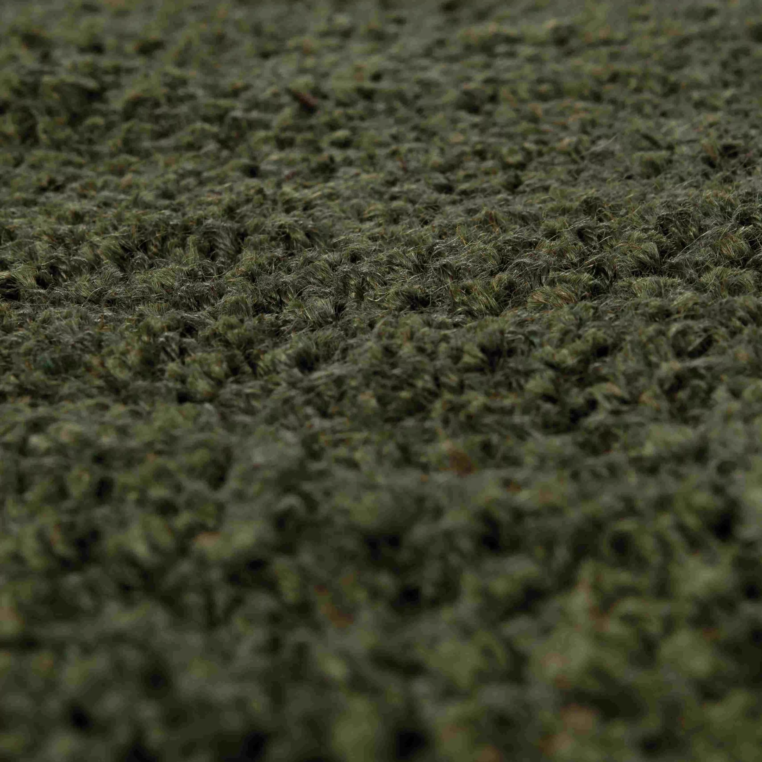 Détail du tissage en jute vert mousse, fibres épaisses et boucles serrées, grain mat et texture naturelle chinée